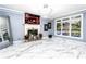 Large living room with a fireplace, large windows, tile floors, modern light fixture, and access to an outdoor deck at 1114 Ivey Chase Pl, Dacula, GA 30019