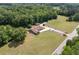 Aerial view of ranch-style house with long drive, detached garage and lush, green surroundings at 1724 Arbor Hill Rd, Canton, GA 30115