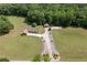 An aerial view of a house with a detached garage and large green lawn surrounded by lush trees at 1724 Arbor Hill Rd, Canton, GA 30115