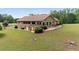 Spacious backyard featuring a brick home, deck and patio, large lawn, and surrounding trees at 1724 Arbor Hill Rd, Canton, GA 30115