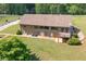 Aerial shot of backyard featuring large lawn, brick home with deck and patio, and surrounding trees at 1724 Arbor Hill Rd, Canton, GA 30115