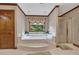 Bright bathroom featuring a jacuzzi tub, separate shower, and elegant fixtures at 1724 Arbor Hill Rd, Canton, GA 30115