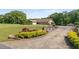 Home featuring long driveway leading to a two-car garage, lush landscaping, and a well-maintained lawn at 1724 Arbor Hill Rd, Canton, GA 30115