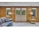Finished living room offers outdoor access via double doors, with neutral carpet and wood paneled walls at 1724 Arbor Hill Rd, Canton, GA 30115