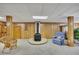Finished living room showcases wood paneled walls, neutral carpet, and a decorative brick fireplace at 1724 Arbor Hill Rd, Canton, GA 30115