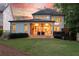 An outdoor living space with a stone fireplace and covered patio to include furniture on a sprawling lawn at 23 Long Island Pl, Sandy Springs, GA 30328