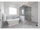 Elegant bathroom showcasing a soaking tub, glass enclosed shower, and white marble tiling at 23 Long Island Pl, Sandy Springs, GA 30328