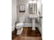 Cozy powder room featuring a pedestal sink, wood floors, and framed artwork at 23 Long Island Pl, Sandy Springs, GA 30328