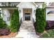 Elegant stone stairway leading to a front door flanked by manicured shrubs and lantern lighting at 23 Long Island Pl, Sandy Springs, GA 30328