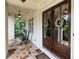 Inviting front porch with stone flooring, rocking chairs, and double doors with glass panels and wreath decorations at 23 Long Island Pl, Sandy Springs, GA 30328