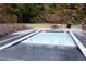 An empty pool has lounge chairs lined up in rows next to it and a rock wall as the backdrop at 23 Long Island Pl, Sandy Springs, GA 30328