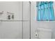 Shower with glass doors and subway tile and a nearby toilet with blue curtains on the window at 2297 Ironwood Hill Ct, Dacula, GA 30019