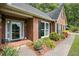 Close-up of brick home's front entrance, highlighting landscaping and covered porch at 2297 Ironwood Hill Ct, Dacula, GA 30019