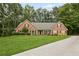 Charming brick home features a lush green lawn, manicured landscaping, and a lengthy driveway at 2297 Ironwood Hill Ct, Dacula, GA 30019