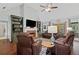 Spacious living room features hardwood floors, a fireplace, built-in shelves, and comfortable leather seating at 2297 Ironwood Hill Ct, Dacula, GA 30019