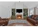 Inviting living room with fireplace, built-in shelving, and comfortable leather furniture at 2297 Ironwood Hill Ct, Dacula, GA 30019