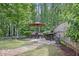 Charming backyard with a stone patio, dining set, grill, and lush landscaping for outdoor enjoyment at 572 Cresentry Brk, Smyrna, GA 30082