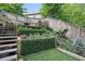 Beautiful tiered backyard with lush greenery, a charming fire pit, and wooden steps for easy access at 572 Cresentry Brk, Smyrna, GA 30082