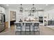Open kitchen with island seating, stainless appliances, hardwood floors and stylish pendant lighting at 572 Cresentry Brk, Smyrna, GA 30082