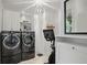 Well-lit laundry room features modern washer and dryer with an exercise bike at 572 Cresentry Brk, Smyrna, GA 30082