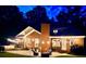 Inviting backyard featuring a patio, cozy seating, fire pit, and well-manicured lawn, illuminated by soft lighting at 8032 Banks Mill Rd, Douglasville, GA 30135
