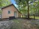 Exterior view of a house and fenced-in area, nestled in a wooded area at 8032 Banks Mill Rd, Douglasville, GA 30135