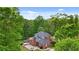 Brick home features a patio with an outdoor seating area surrounded by lush trees and greenery on a large lot at 8032 Banks Mill Rd, Douglasville, GA 30135