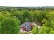 Brick home with a rear patio and firepit surrounded by a lush, vibrant green forest on a large, private lot at 8032 Banks Mill Rd, Douglasville, GA 30135