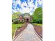 Stunning two-story brick home showcasing a beautiful walkway and professionally landscaped front yard at 8032 Banks Mill Rd, Douglasville, GA 30135