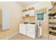 Bright laundry room featuring a washer, dryer, cabinets, shelves and storage for a clean and organized space at 8032 Banks Mill Rd, Douglasville, GA 30135