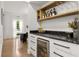 Convenient bar area with wine refrigerator, built-in storage, and hardwood floors at 2180 Dunwoody Heritage Dr, Atlanta, GA 30350