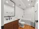 Modern bathroom with wood vanity, black faucet, and a tub with tiled walls and rain shower head at 2180 Dunwoody Heritage Dr, Atlanta, GA 30350