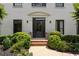 Elegant front entrance featuring black door, brick steps, and decorative plantings at 2180 Dunwoody Heritage Dr, Atlanta, GA 30350