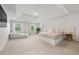 Spacious main bedroom featuring tray ceilings, a seating area, and a large bed with an upholstered headboard at 2180 Dunwoody Heritage Dr, Atlanta, GA 30350