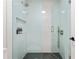 Contemporary shower with glass enclosure, sleek fixtures, a built-in niche, and stylish dark-tiled floor at 2180 Dunwoody Heritage Dr, Atlanta, GA 30350