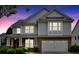 Charming two-story home with a covered front porch illuminated at dusk showcasing its architectural features at 221 Hampton Station Blvd, Canton, GA 30115