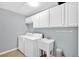 Laundry room with white cabinets above washer and dryer, with a sink, and neutral walls at 221 Hampton Station Blvd, Canton, GA 30115