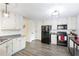 Well-lit kitchen with stainless steel appliances, wood-look floors, and white cabinets at 2410 Bankstone Sw Dr, Marietta, GA 30064