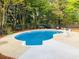 Beautiful backyard with a large private pool, surrounded by green trees, and a concrete patio with seating at 2410 Bankstone Sw Dr, Marietta, GA 30064