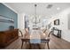 Elegant dining room with hardwood floors, chandelier, and a view into the kitchen and living areas at 3239 Bartee Walk, Suwanee, GA 30024