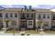 Charming townhomes boast brick exteriors with black accents and well-manicured lawns at 3239 Bartee Walk, Suwanee, GA 30024