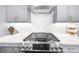 Gourmet kitchen featuring a gas cooktop, stainless steel range hood, and subway tile backsplash at 3239 Bartee Walk, Suwanee, GA 30024