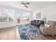 Bright living room features hardwood floors, a ceiling fan, a leather sofa, and access to a balcony at 3239 Bartee Walk, Suwanee, GA 30024