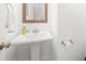 Clean powder room features pedestal sink, framed mirror, and classic fixtures at 3239 Bartee Walk, Suwanee, GA 30024