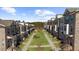 A street view featuring recently constructed brick townhomes with manicured lawns, sidewalks, and meticulously maintained landscaping at 3239 Bartee Walk, Suwanee, GA 30024