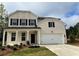 Charming two-story brick home features a two-car garage, covered front porch, and manicured lawn at 3311 Burkston Pl, Buford, GA 30519