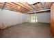 Unfinished basement features exposed wood ceiling, concrete floor, and sliding glass doors to the yard at 110 Vistacrest Way, Roswell, GA 30075