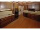 Kitchen view with a double oven, flat cook top, and sink beneath wood cabinets and wood flooring at 110 Vistacrest Way, Roswell, GA 30075