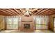 View of living room with brick fireplace, bare flooring and ceiling, and exposed framing at 110 Vistacrest Way, Roswell, GA 30075