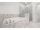Bathroom with a luxurious soaking tub and a glass-enclosed shower, featuring stylish tile work at 244 Church St, Lawrenceville, GA 30046